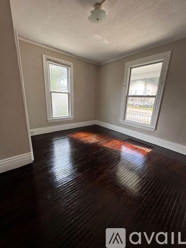 A bedroom with a bed, dresser, and a door.