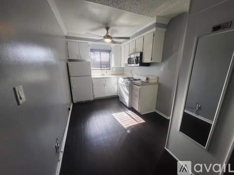 A kitchen with white cabinets and a ceiling fan.