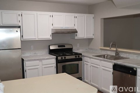 A kitchen with white cabinets and a stainless steel refrigerator.