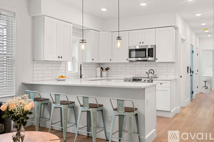 A kitchen with white cabinets and a wooden floor.