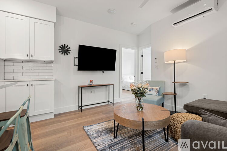 A living room with a flat screen TV mounted on the wall above a coffee table.