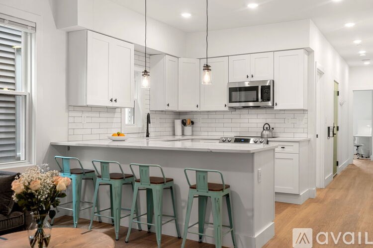 A kitchen with white cabinets and a white counter top.
