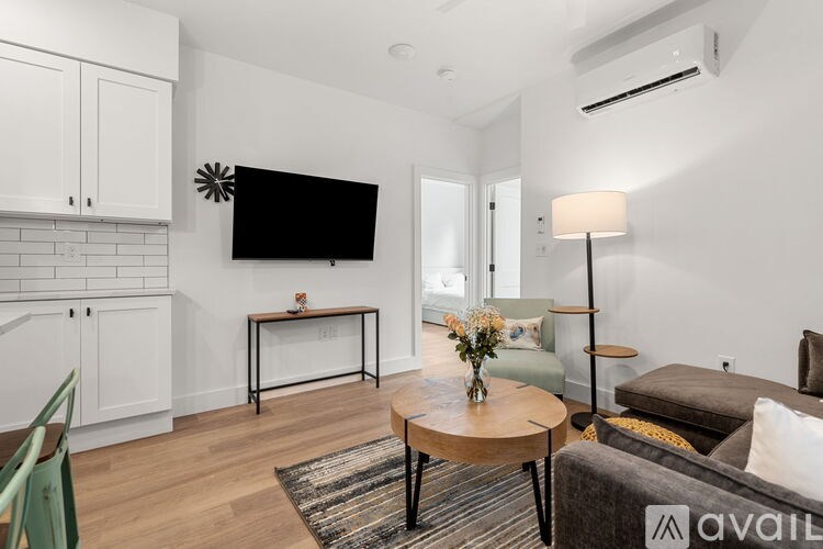 A living room with a flat screen TV mounted on the wall.