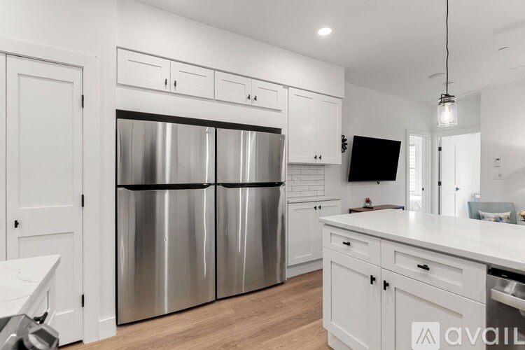 A modern kitchen with stainless steel appliances and white cabinetry.