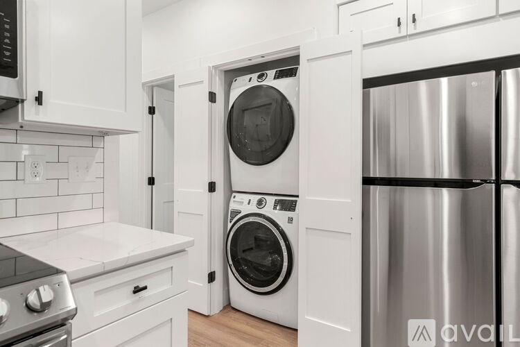 A modern kitchen with a stainless steel refrigerator, a white oven, and a white dishwasher.
