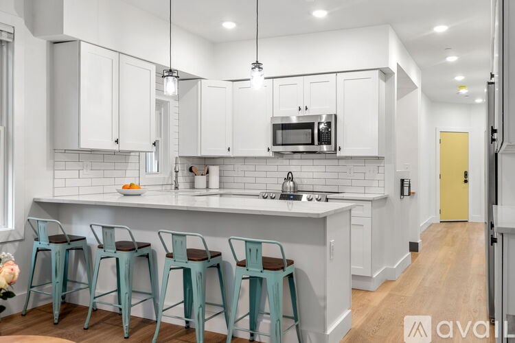 A kitchen with white cabinets and a countertop with a microwave on it.