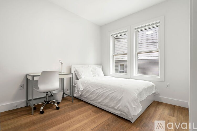 A bedroom with a bed, desk, and chair.
