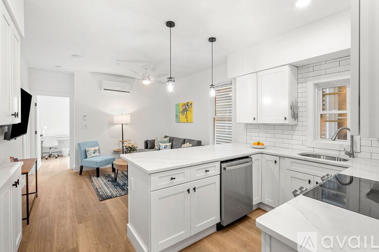 A modern kitchen with white cabinets and a large island.