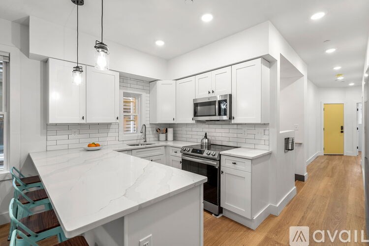 A modern kitchen with white cabinets and a marble countertop.