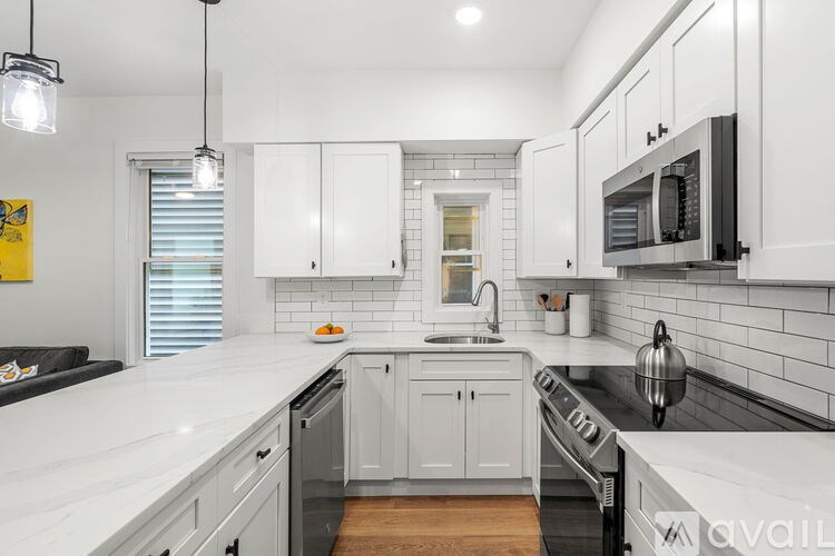 A kitchen with white cabinets and a black stove top.