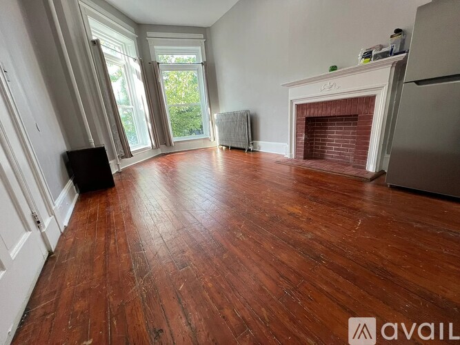 A room with a fireplace and wooden floors.