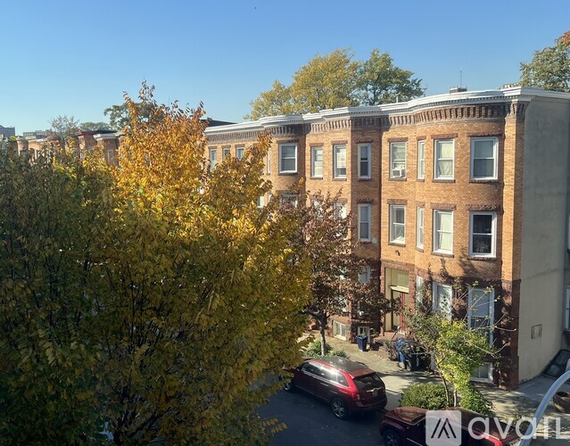 A tree with yellow leaves is in front of a building.
