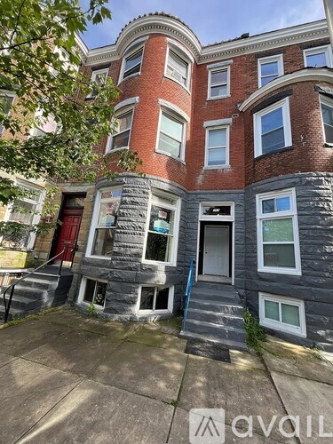 A red and grey building with a staircase leading to the front door.