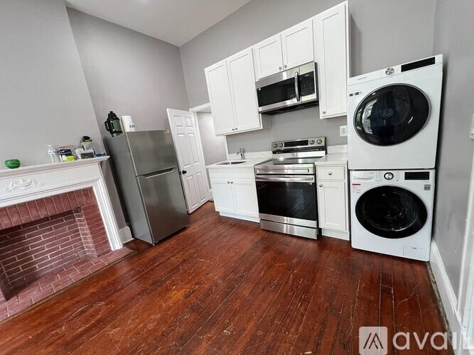 A kitchen with white cabinets and a wood floor.
