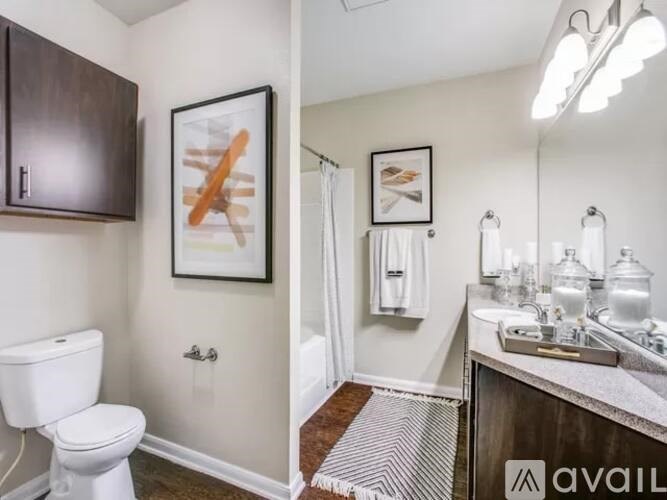 A bathroom with a toilet, sink, and mirror.