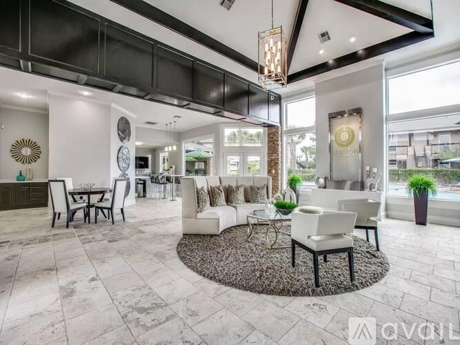 A living room with a white sofa set and a black and white rug.