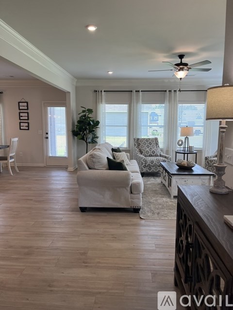 A living room with a white couch and a ceiling fan.