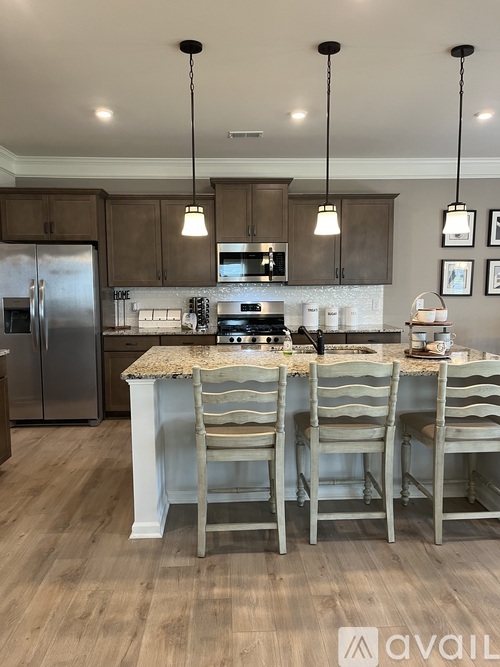 A kitchen with a table and chairs in front of a refrigerator and microwave.