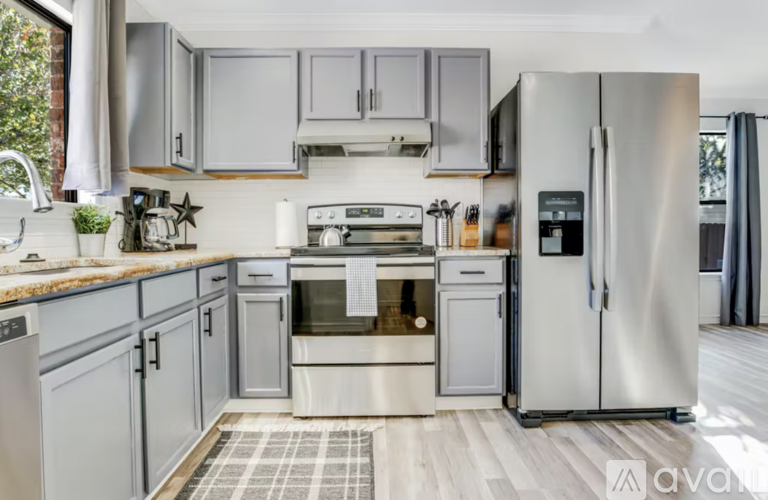 A modern kitchen with a stainless steel refrigerator and oven.