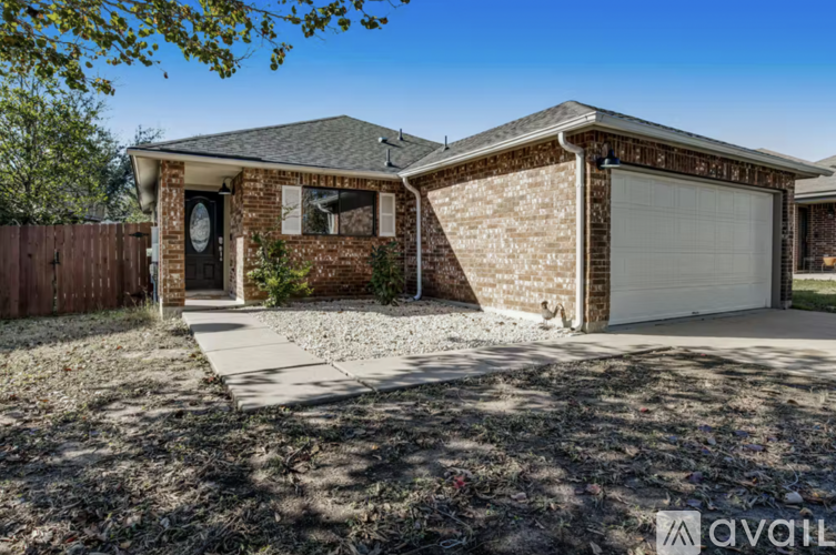 A house with a brown brick exterior and a white garage door.