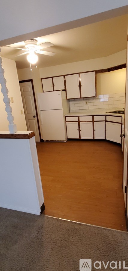 A kitchen with white cabinets and a white fridge.