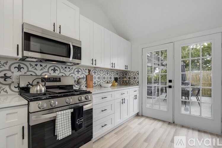 A kitchen with white cabinets and a black stove top oven.