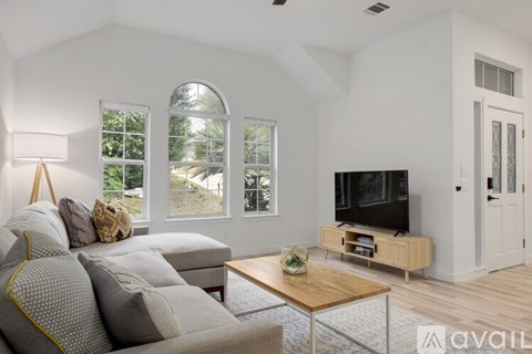 A living room with a grey couch and a wooden coffee table.