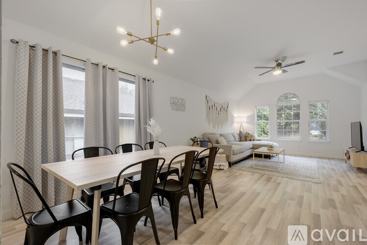 A dining room with a table set for six and a television in the corner.