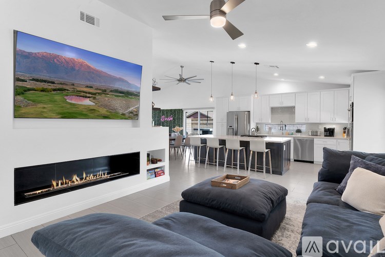 A modern living room with a large painting on the wall and a fireplace.