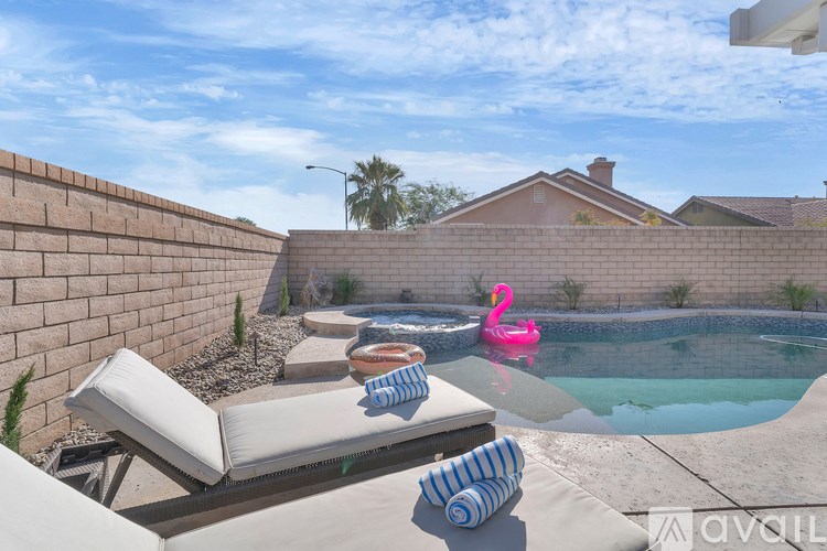 A pool with a pink flamingo float in it.