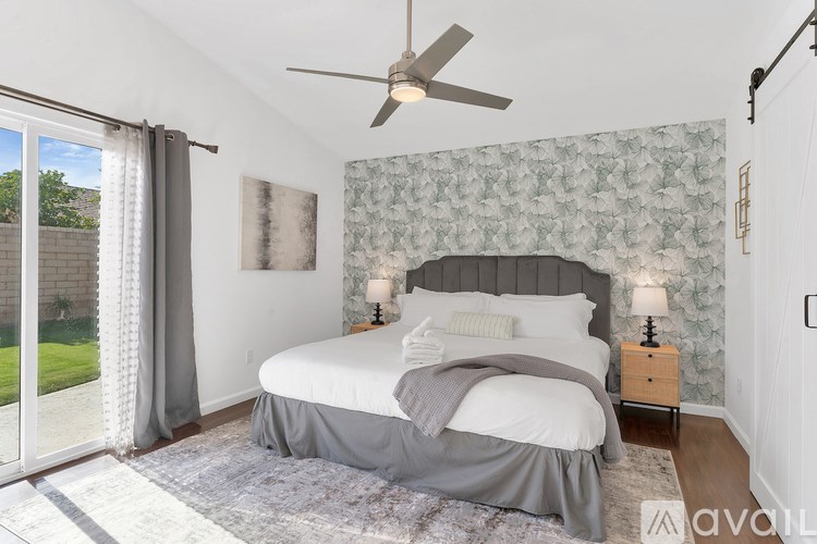 A bedroom with a large bed and a ceiling fan.
