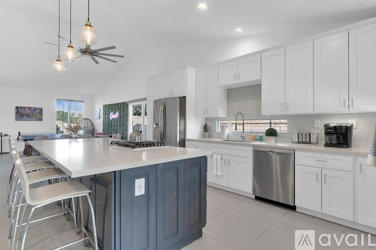 A modern kitchen with a large island and stainless steel appliances.
