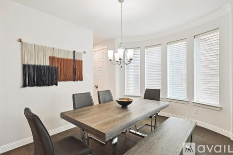 A dining room with a wooden table and chairs.