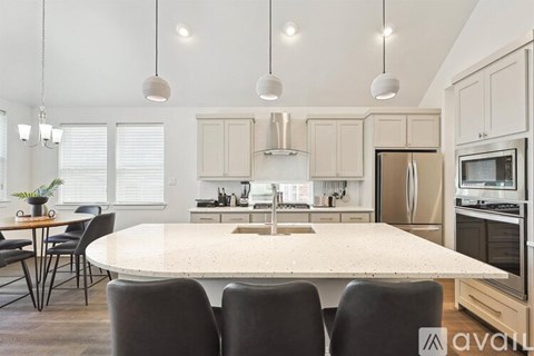 A kitchen with a table and chairs in front of it.