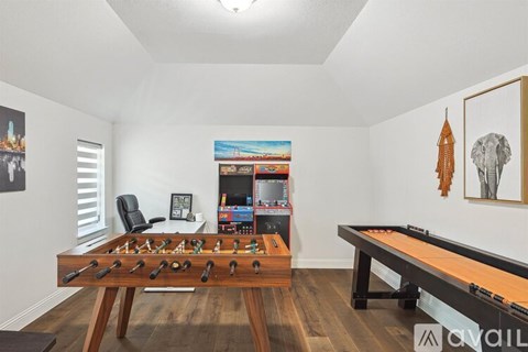 A room with a foosball table and a pool table.
