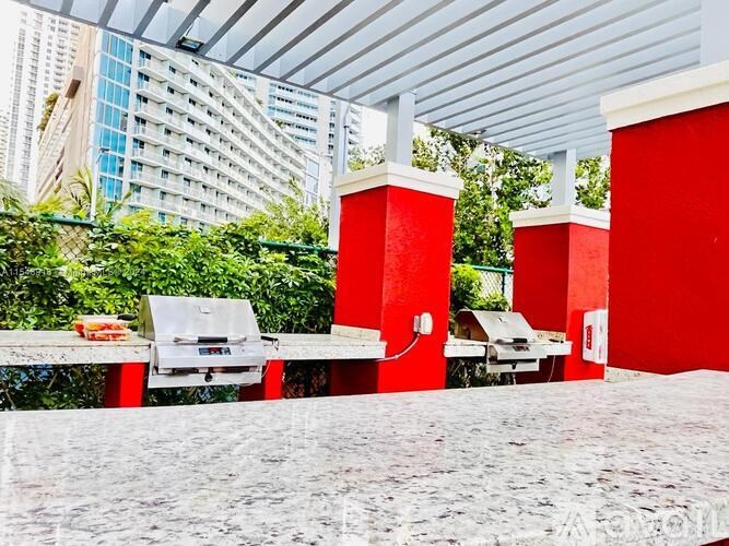 A red and white outdoor seating area with grills and tables.