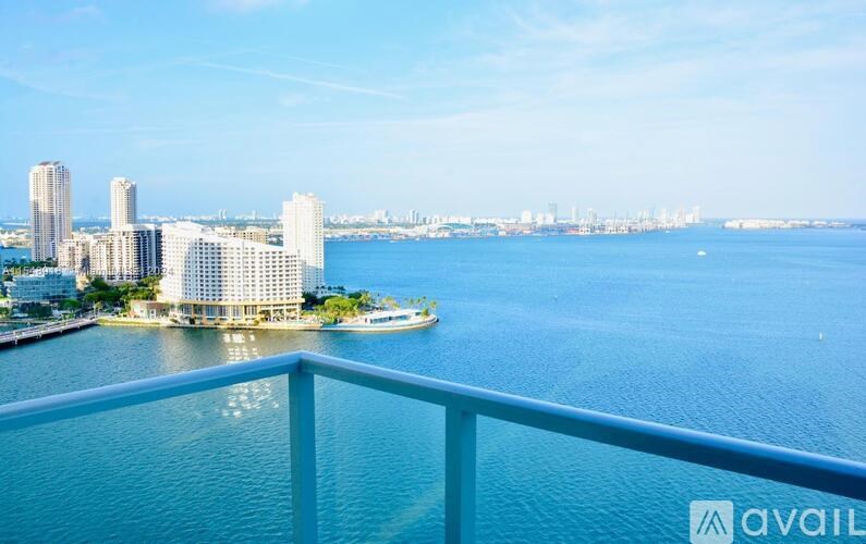 A view from a balcony overlooking a body of water with buildings in the distance.