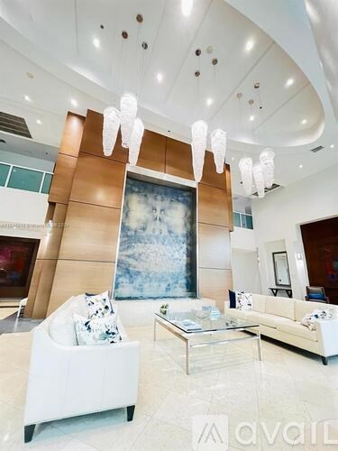 A living room with a large painting, a white sofa, and a glass coffee table.