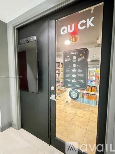 A black door with a glass window showing a store interior.