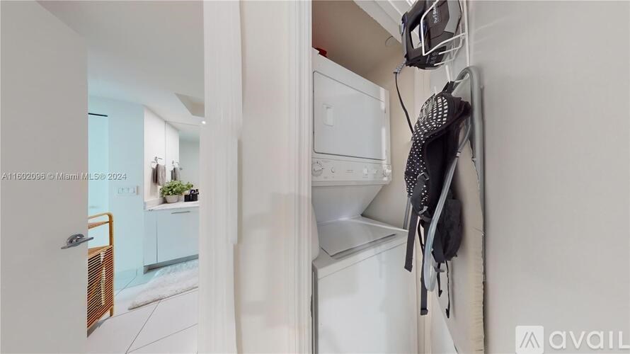 A kitchen with a white dishwasher and a black and white striped towel hanging on the wall.
