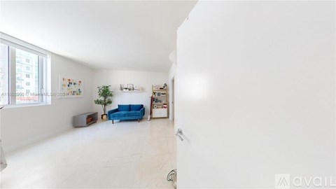 A living room with a blue sofa and a white wall.