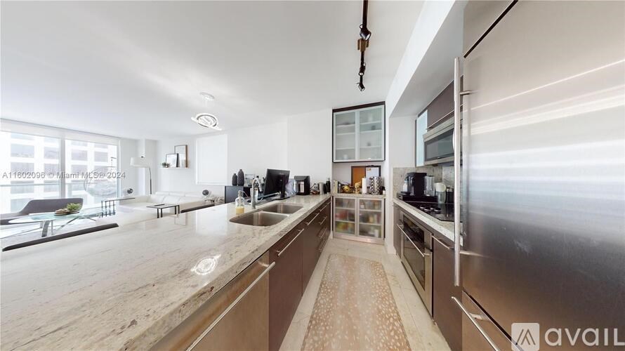 A modern kitchen with stainless steel appliances and a wooden countertop.