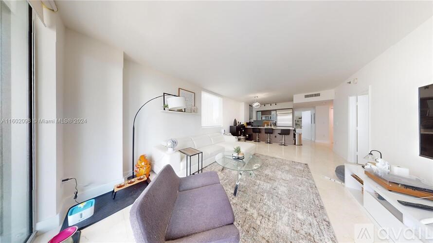 A modern living room with a purple couch and a glass table.