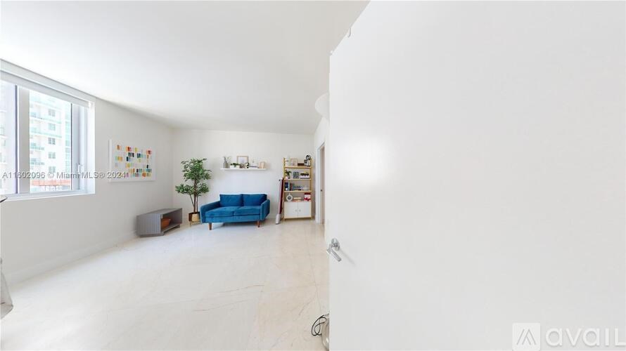 A living room with a blue sofa and a white wall.