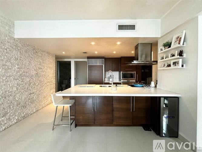 A modern kitchen with a white countertop and dark wood cabinets.