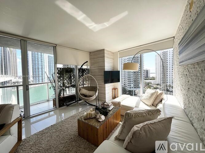 A modern living room with a large window overlooking a cityscape.