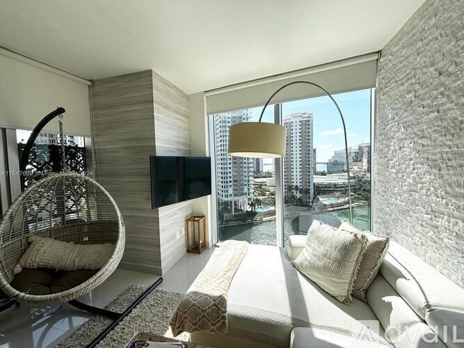 A modern living room with a large window overlooking a cityscape.