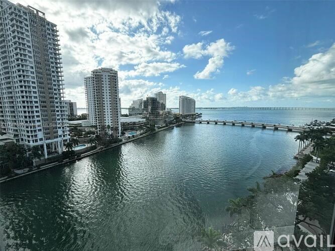 A cityscape with a body of water in the foreground and buildings in the background.