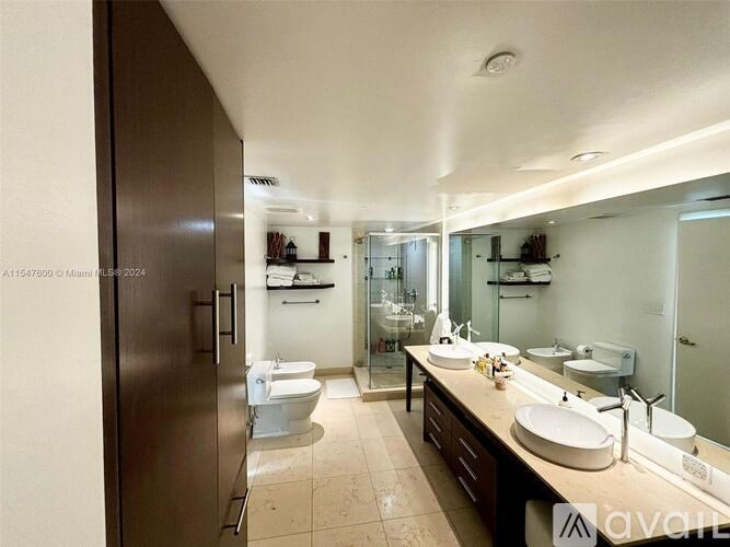 A bathroom with a sink, toilet, and shower.