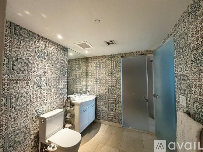 A bathroom with a toilet, sink, and shower.